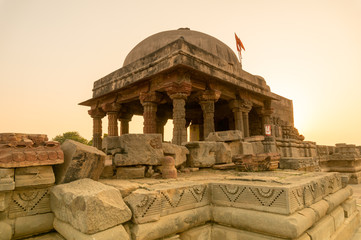 Old brown stone temple at Abhaneri shot at sunset. The temple near the baori with it's stone pillars, domed roof and the carved stone walls. This landmark and monument is a popular tourist place