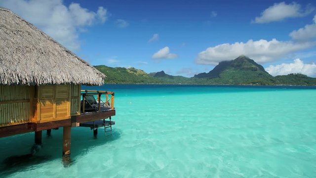 Time lapse view of aquamarine lagoon Overwater luxury Bungalows in tropical Tahitian vacation resort of Bora Bora Island in the South Pacific