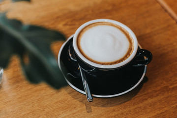 hot coffee in black cup on wooden table.