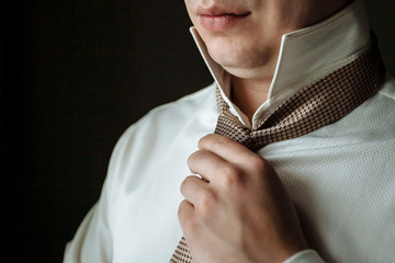 Man in a shirt straightens his tie