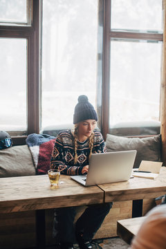 Woman Working on Her Laptop at Log Cabin