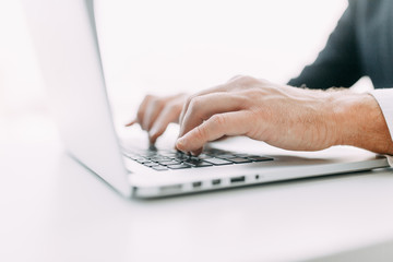 Hands at work on a laptop with bokeh. Business situation, isolated background.