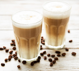 Two glasses of latte coffee and coffee beans