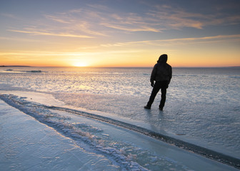 Winter landscape and man looking on sunset