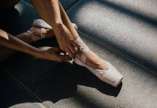 Crop ballerina tying pointe shoes