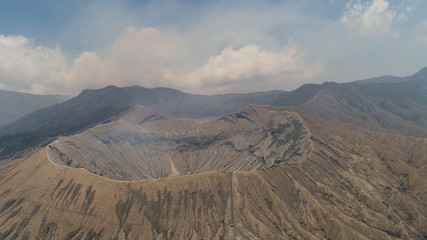 Naklejka premium active volcano Bromo with smoking crater. aerial view mountain landscape volcano crater and mountains Tengger Semeru national park.
