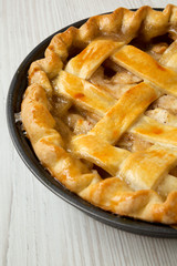 Homemade apple pie on white wooden surface, side view. Closeup.
