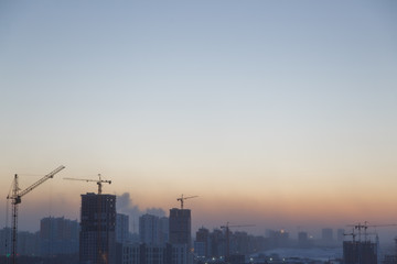 Construction of the building at dawn. Background the city of industry.