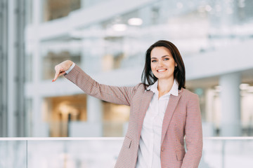 Fototapeta premium A beautiful girl points and makes a choice. Business coach and coach of advertising goods.
