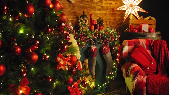 Closeup image of red gift box on wooden table in front of burning fireplace and Christmas tree 4K