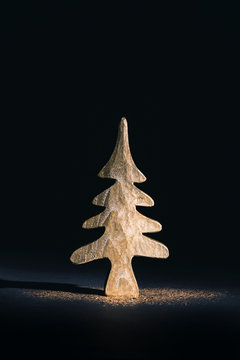 Mini golden Christmas tree with glitter on black background