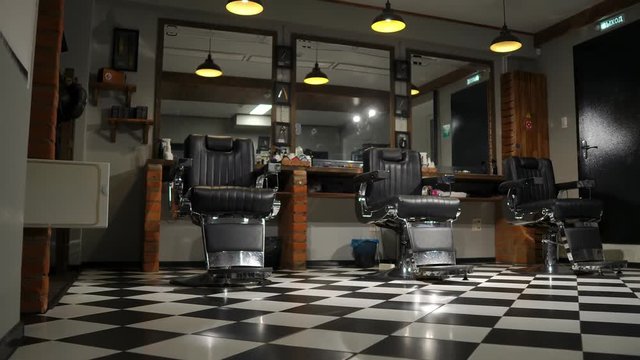 Vintage hanging lamps in hairdressing salon. Ceiling retro lamp in barber shop. Barber pole. Hair salon interior. Metal ceiling lights in barbershop