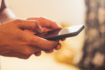 close up of a man holding and using a smart phone