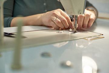 A woman sews on an electric sewing machine.
