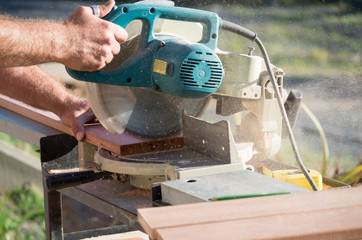 Man doing home renovations cutting wood with a saw