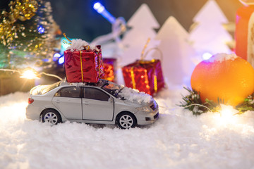 Fototapeta na wymiar Toy car carries gifts in the new year. Concept of the Christmas mood