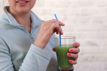 Woman drinking fresh raw green detox vegetable juice. Healthy lifestyle