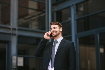 Businessman walking outdoors and talking on phone