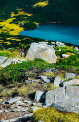 Hiking trail, clean water in the blue lake. Rocky mountains, alpine hiking route.