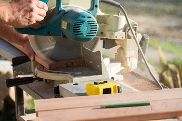 Man doing home renovations cutting wood with a saw