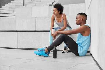 View of pensive youngsters have sporty body shape, motivation to be healthy and fit, do sport in...