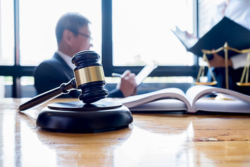 Judge gavel with Justice lawyers having team meeting at law firm background. Concepts of Law and Legal services.