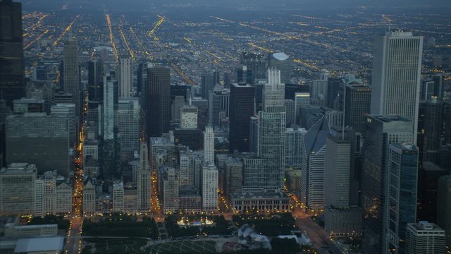 Aerial illuminated view at sunrise of Sears Tower Aon Center Chicago Skyscraper buildings and Millennium Park Illinois USA 