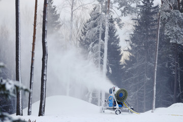 Professional snow machine that makes snow out of the water. Beautiful forest landscape