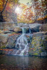 Small waterfalls cascade in autumn season colors in the forest near Vladivostok, Russia