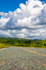 Winding country road and cloudy blue sky