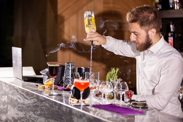 bartender pouring cocktail incredients. Lounge atmosphere