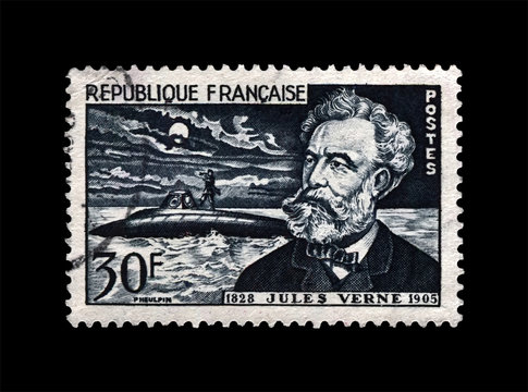 Jules Verne (1828-1905), famous fantastic science writer and Nautilus submarine, circa 1955. canceled vintage postal stamp printed in France isolated on black background.