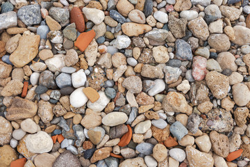 Abstract top view background of many colourful dry stones at sea beach. Horizontal color...