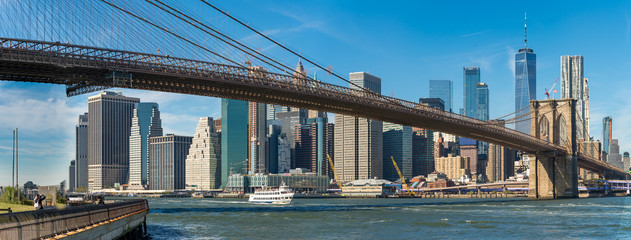 Panoramic view of Brooklyn bridge over Manhatten skyscrapers in New York.
