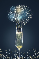 Sektglas mit Feuerwerk und Bokeh