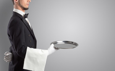 Waiter serving with white gloves and steel tray in an empty space
