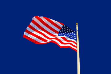 United States national flag waving in the wind against blue background