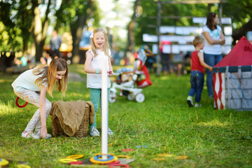 Children playing ring toss game during annual Medieval Festival, held in Trakai Peninsular Castle.
