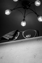 Glasses on edge of table with lens cloth and lights above