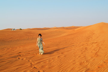 Fototapeta na wymiar silhouette of a girl in the setting sun in the desert in the United Arab Emirates