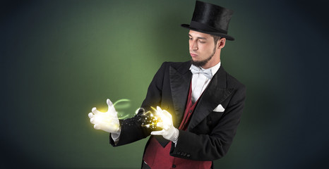 Magician holding his sparkling power between his two hand