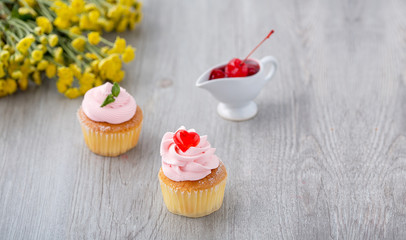 Tasty cupcake on wooden background. Birthday cupcakes on gray wooden background. Cupcakes with heart-shaped jellies. Space for Text. Cupcake Thailand.