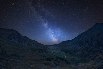 Digital composite Milky Way image of Beautiful dramatic landscape image of Nant Francon valley in Snowdonia © veneratio