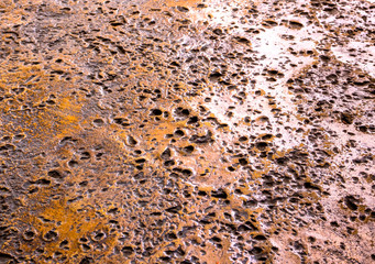 Many rugged holes on the rusty color concrete floor