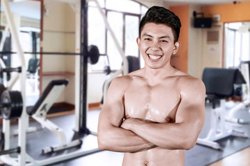Fototapeta na wymiar Muscular man looks confident in gym center