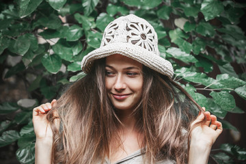 Caucasian girl without makeup in a wicker hat handmade on the background of nature. Concept - life in natural and natural conditions far from civilization