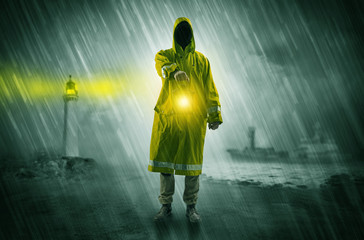 Man at the coast coming in raincoat with glowing lantern concept
