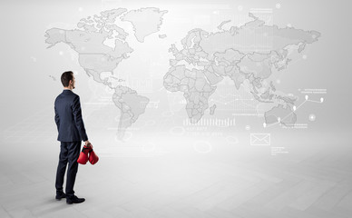 Fototapeta premium Businessman standing with his back and looking at a worldwide map with objects in his hand 