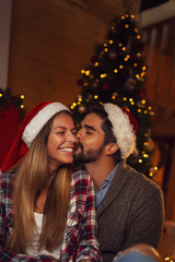 Fototapeta na wymiar Couple kissing by the Christmas tree