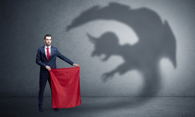 Businessman standing with red cloth in his hand and imp shadow on the background
